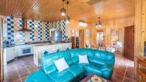 un salon avec un canapé bleu et une cuisine dans l'établissement Cortijo La Tata Almayate Alto by Ruralidays, à Almayate Alto