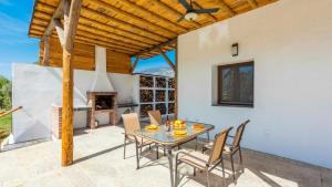 a patio with a table and chairs and a fireplace at Cortijo Villa Maroma Órgiva by Ruralidays in Órgiva