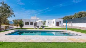 a villa with a swimming pool in front of a house at Cortijo Villa Maroma Órgiva by Ruralidays in Órgiva