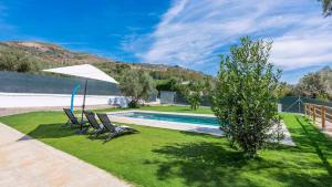 a yard with two chairs and a swimming pool at Cortijo Villa Maroma Órgiva by Ruralidays in Órgiva