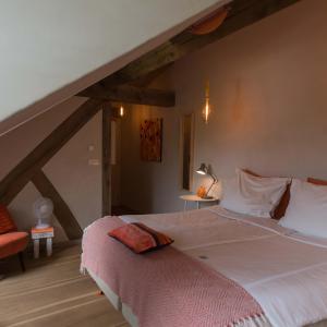 a bedroom with a large bed in a attic at Domein Holset BruisendWijnHuis in Lemiers