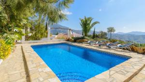 una piscina in una villa con montagne sullo sfondo di The Hunting Lodge Alcaucín by Ruralidays ad Alcaucín