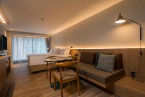 um quarto de hotel com uma cama, uma mesa e um sofá em Hotel Luzeiros Fortaleza em Fortaleza