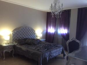 1 dormitorio con 1 cama, 2 mesas y lámpara de araña en Hostal Mont Royal en Alicante