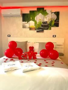 un grupo de globos rojos en una cama en B&B suite spa la Sciantosa, en Cosenza