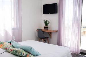 - une chambre avec un lit et une télévision murale dans l'établissement Sunrise Beach Hotel, à Gruissan
