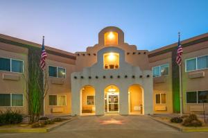 a building with two american flags in front of it at Quality Inn Alpine in Alpine