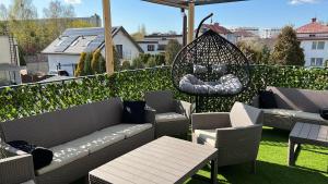 a patio with couches and chairs on a balcony at Comfort Zone Ostróda Villa Apartment Duplex in Ostróda
