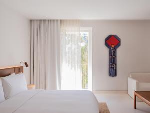 a bedroom with a bed and a clock on the wall at The Standard, Ibiza in Ibiza Town