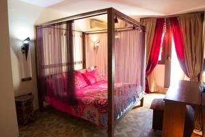 a bedroom with a canopy bed with pink pillows at Hostal Mont Royal in Alicante