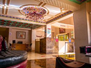 a lobby with a glass table and a chandelier at Hotel L'Aéroport in Nador