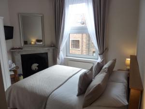 a bedroom with a white bed and a window at Lavinia House in Whitby