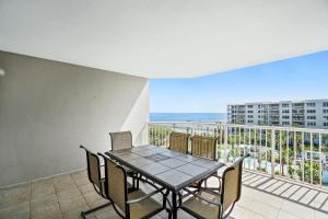 a dining room with a table and chairs and a balcony at Destin West - Heron in Fort Walton Beach
