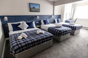 a hotel room with two beds and a couch at Glasha Meadows Accommodation in Doolin