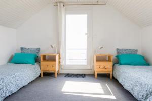 two twin beds in a room with a window at Kan ar Moor et sa vue Mer exceptionnelle! in Pouldreuzic
