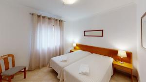 Giường trong phòng chung tại Praia da Lota Resort – Beachfront Apartments