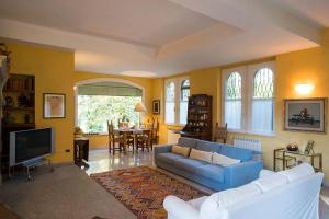 a living room with a blue couch and a tv at Villa Solaria in Alessandria