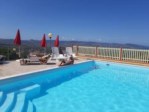a woman sitting in a chair next to a swimming pool at Casa vacanze "La Caldosa" in Badesi