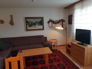 sala de estar con sofá, mesa y TV en Bot Sundroina (329 Pe) Whg. 2.3, en Lenzerheide