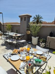a table with breakfast food on a patio at Riad les Rêves d'Amélie in Marrakesh