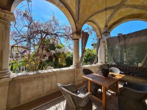 a porch with a table and chairs and a window at Heritage Apartment Park Royal Residence in Opatija