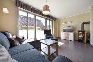 uma sala de estar com um sofá e uma mesa em Ferienhaus Sonneninsel 5c em Korswandt