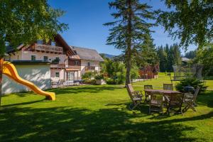 a backyard with a table and chairs and a slide at Mühlrad Appartements in Ramsau am Dachstein