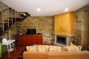 ein Wohnzimmer mit einem Sofa und einem Kamin in der Unterkunft Casa da Laranjeira Turismo Rural in Vieira do Minho