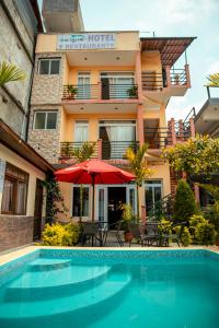 a hotel with a swimming pool in front of a building at El Delfin Hotel y Restaurante in San Pedro La Laguna