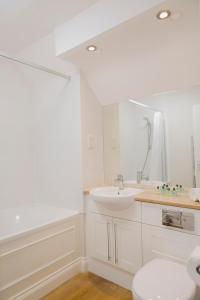 a bathroom with a sink, toilet, and bathtub at Beaulieu Hotel in Lyndhurst