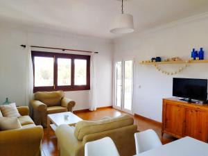 ein Wohnzimmer mit zwei Sofas und einem Fernseher in der Unterkunft Villa Ferrer in Port d'Addaia