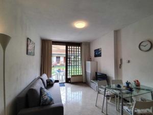 een woonkamer met een bank en een glazen tafel bij Pleasant apartment in Feriolo di Baveno on the lake in Fondotoce
