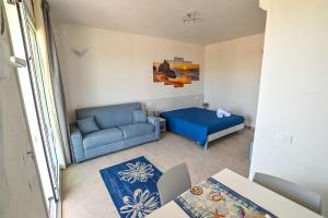 un soggiorno con un divano blu e un letto di ARIA D'ORIENTE a Uggiano la Chiesa