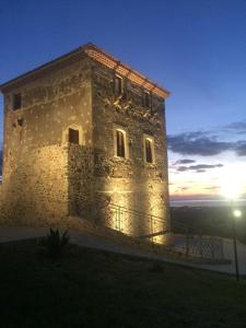 un grande edificio in pietra con il tramonto sullo sfondo di B&B Il Grillo a Santa Maria del Cedro