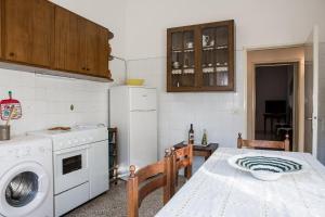 a kitchen with a table and a white refrigerator at Nonna Sonia in Castiglione della Pescaia