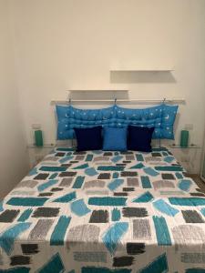 un letto con testiera blu e cuscini blu di LA TORRETTA A SAN TERENZO a Lerici