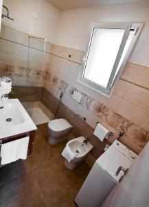un bagno con un water, un lavandino e una finestra di ARIA D'ORIENTE a Uggiano la Chiesa Altre 17 foto