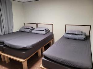 two twin beds sitting in a room withermottermott at Able Guesthouse Hongdae in Seoul