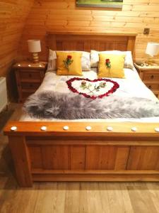 a bed in a room with two night stands and two lamps at Tollymore Luxury log cabins in Newry