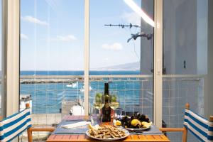 a table with a plate of food and a bottle of wine at Lampara Mare in Vico Equense