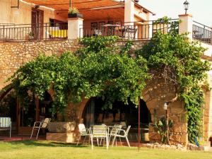 a group of chairs and tables in front of a building at La Masia Costa Brava -Adults Only in Garrigás