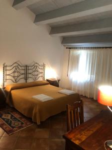 1 dormitorio con cama, mesa y ventana en Torre Archirafi Resort en Riposto