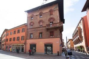 een hoog bakstenen gebouw met een balkon in een straat bij 45 - Tourist House Bologna Oberdan - Self check-in in Bologna