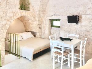 um quarto com uma cama, uma mesa e cadeiras em Il Piccolo Frantoio em Ostuni