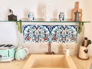 un bancone della cucina con lavandino e un tuffo con ripieno di piastrelle di Il Piccolo Frantoio - Locazione Turistica a Ostuni