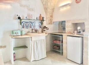 una cucina con un lavello e un bancone di Il Piccolo Frantoio - Locazione Turistica a Ostuni