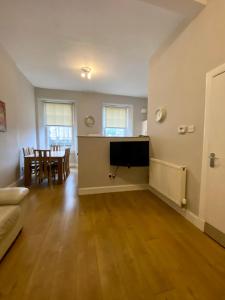 an empty living room with a table and a tv at Grassmarket apartment in Edinburgh