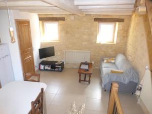 a living room with a couch and a tv at Gîte la grange in Domme
