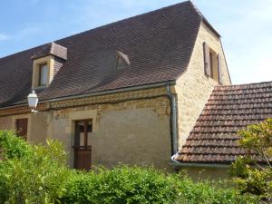 une grande maison en pierre avec un toit gris dans l'établissement Gîte la grange, à Domme