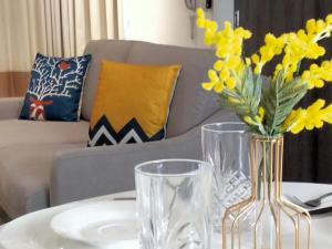 Una mesa con dos jarrones y flores amarillas. en Continew Residence by HomeBrickz, en Kuala Lumpur